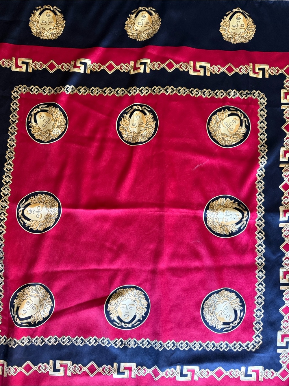 square scarf black border and a bold red center adorned with gold Medusa